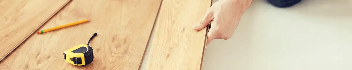 A professional installing wood flooring in Tuscaloosa, AL